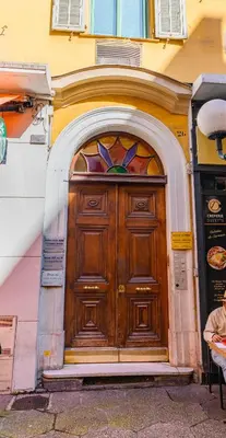 a large wooden door in the side of a building at Hyper Centre, balcon, 5min de la plage, AC in Nice