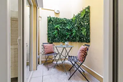 a small balcony with a table and chairs at 1 Bdr Duplex Downtown - AC in Nice