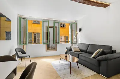 a living room with a black couch and a table at Saint-Augustin - Nice Old Town in Nice
