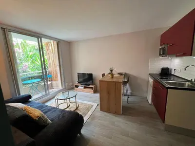 a living room with a couch and a kitchen at Les Magnolias 06 in Nice