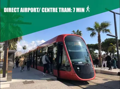 a red tram is parked at a bus stop at Votre COCON Niçois Appart Vue Mer in Nice