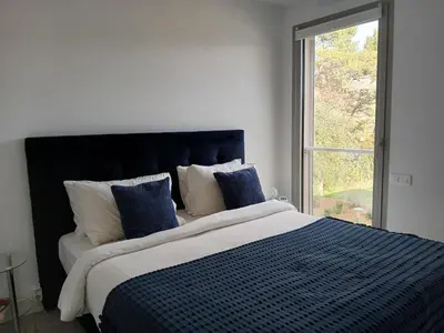 a bedroom with a large bed with blue and white pillows at Laconsolate in Nice