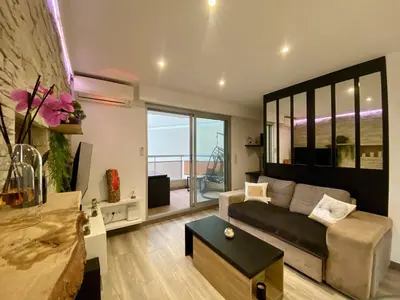 a living room with a couch and a table at F1 Saint Laurent du Var Proximity to beach-Clim Wifi in Saint-Laurent-du-Var