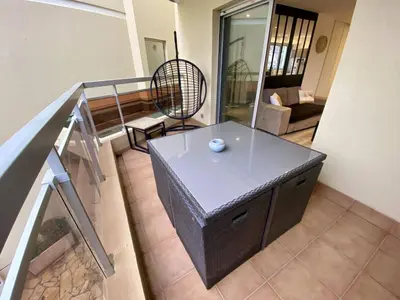 a living room with a table and a couch at F1 Saint Laurent du Var Proximity to beach-Clim Wifi in Saint-Laurent-du-Var