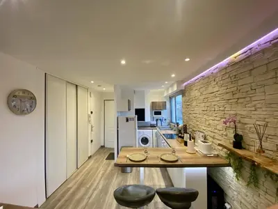 a kitchen with a table and a brick wall at F1 Saint Laurent du Var Proximity to beach-Clim Wifi in Saint-Laurent-du-Var