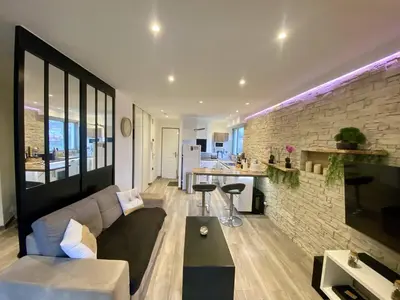 a living room with a couch and a brick wall at F1 Saint Laurent du Var Proximity to beach-Clim Wifi in Saint-Laurent-du-Var