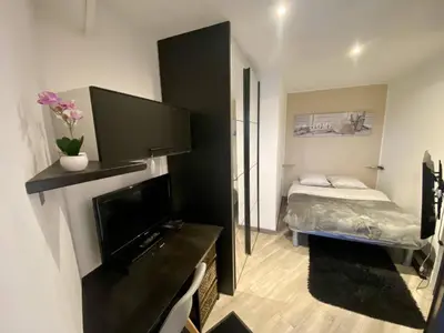 a small bedroom with a bed and a flat screen tv at F1 Saint Laurent du Var Proximity to beach-Clim Wifi in Saint-Laurent-du-Var