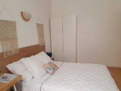 a bedroom with a white bed and a table at 3 rooms GEM in Old Town Nice in Nice