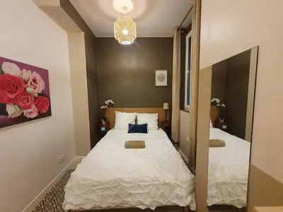 a small bedroom with a bed and a mirror at 3 rooms GEM in Old Town Nice in Nice
