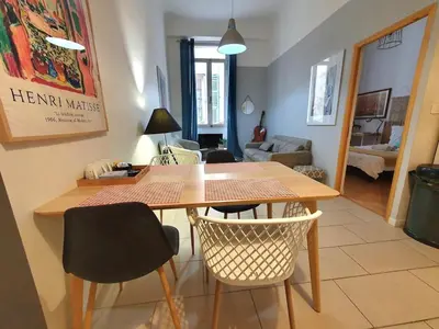 a dining table and chairs in a living room at 3 rooms GEM in Old Town Nice in Nice