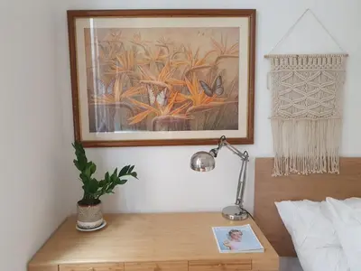 a desk with a lamp and a painting on the wall at 3 rooms GEM in Old Town Nice in Nice
