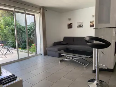 a living room with a couch and a table at Proche bord de mer, au calme, nature avec piscine in La Gaude