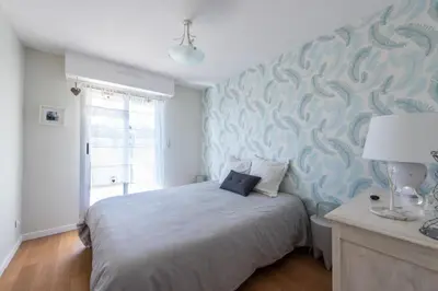 a bedroom with a bed with a blue wall at Happyfew la terrasse de Selfina in Nice