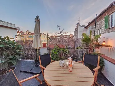 a wooden table with two glasses and an umbrella at Nestor&Jeeves - TERRASSE DU SUD - Central - Terrace in Nice