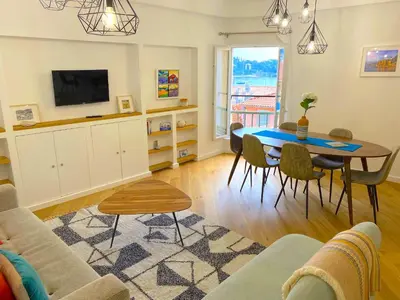 a living room with a table and a tv at LARA AP4441 By Riviera Holiday Homes in Villefranche-sur-Mer