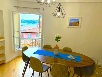 a dining room with a table and chairs and a window at LARA AP4441 By Riviera Holiday Homes in Villefranche-sur-Mer