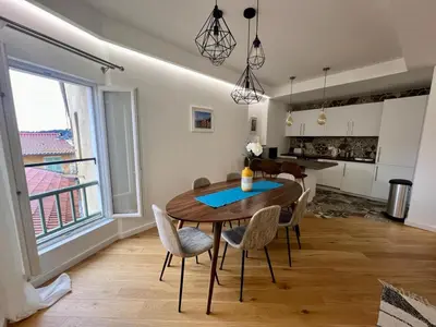 a kitchen and dining room with a wooden table and chairs at LARA AP4441 By Riviera Holiday Homes in Villefranche-sur-Mer
