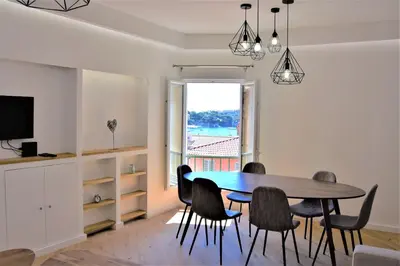a dining room with a table and chairs and a window at LARA AP4441 By Riviera Holiday Homes in Villefranche-sur-Mer