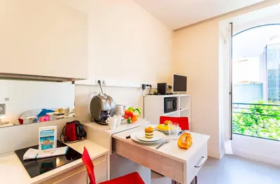 a kitchen with a table and chairs and a window at Studio hyper-centre de Nice in Nice