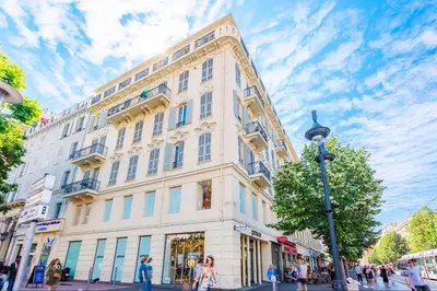 a large white building on a city street with people walking at Studio hyper-centre de Nice in Nice