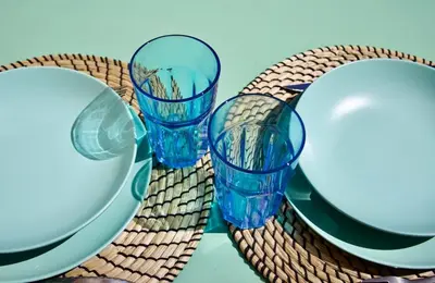 three blue glasses sitting on a table with plates at Studio with Big terrace full center with air conditioning in Nice