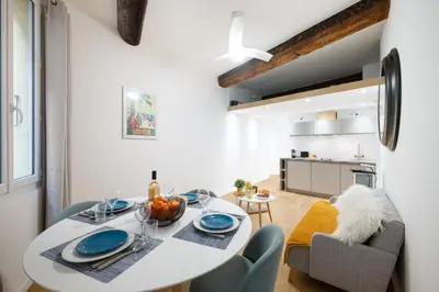 a kitchen and dining room with a white table and chairs at Le Castelosa - Au coeur du Vieux-Nice in Nice