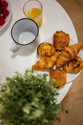 a plate of pastries on a table with a glass of milk at Le Castelosa - Au coeur du Vieux-Nice in Nice