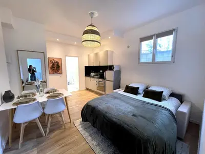 a bedroom with a bed and a table and chairs at Joli 2 pièces avec terrasse, proche mer in Nice
