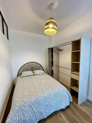 a bedroom with a bed and a light at Joli 2 pièces avec terrasse, proche mer in Nice