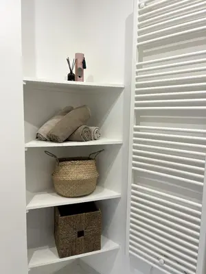 a white closet with white shelves and a basket at Joli 2 pièces avec terrasse, proche mer in Nice
