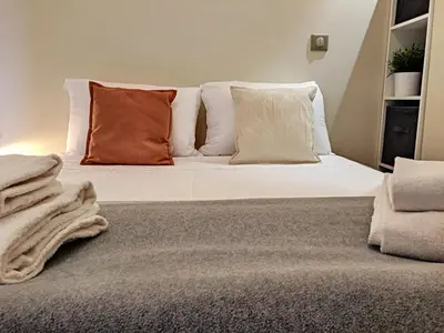 a bed with white sheets and orange pillows at Nestor&Jeeves - KORNER AVENUE TERRASSE - Central - Balcony in Nice