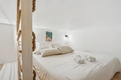 a bedroom with a white bed with towels on it at La Promenade Niçoise in Nice