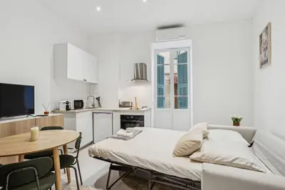 a white living room with a couch and a table at La Promenade Niçoise in Nice