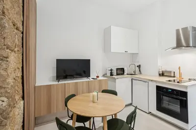 a kitchen with a wooden table and chairs in a room at La Promenade Niçoise in Nice