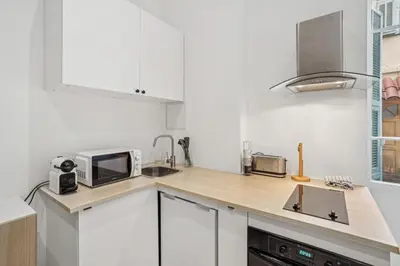 a white kitchen with a sink and a microwave at La Promenade Niçoise in Nice