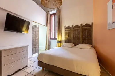 a bedroom with a bed and a tv on a wall at Proche du Cours Saleya et de la plage, dans le vieux Nice, spacieux et climatisé in Nice