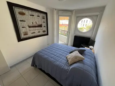 a bedroom with a blue bed and a window at Nice Massena 2 rooms in Nice
