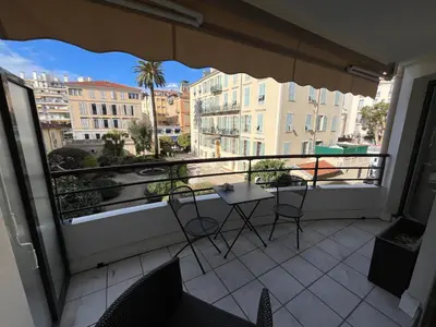 a balcony with chairs and a table and a view of a city at Nice Massena 2 rooms in Nice