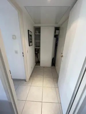 a hallway with white walls and a tiled floor at Nice Massena 2 rooms in Nice
