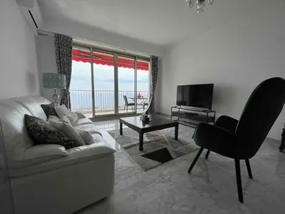 a living room with a white couch and a television at Beautiful Apartment Pool & Garage See View in Nice