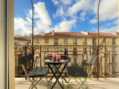 a table and chairs on a balcony with a building at Nice Gare Studio in Nice