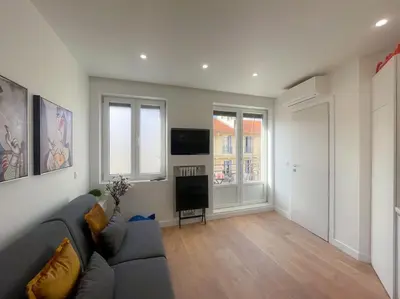 a living room with a couch and a flat screen tv at Nice Gare Studio in Nice