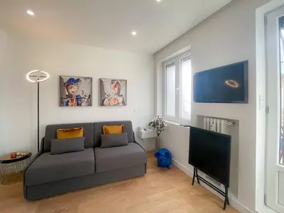 a living room with a couch and a flat screen tv at Nice Gare Studio in Nice