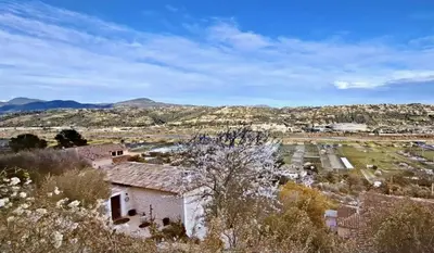 a view of a farm with mountains in the background at Chambres d'hôtes D'AQUI D'AIA in Saint-Laurent-du-Var
