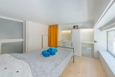 a bedroom with a bed with blue pillows on it at MUSICIENS Joli DUPLEX 2 Chambres Garage privatif et Terrasse in Nice