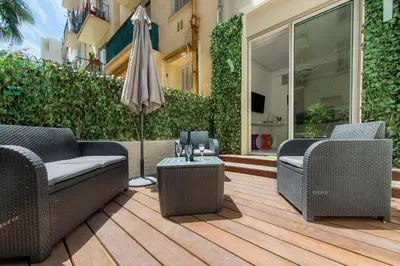 a patio with two chairs and an umbrella at MUSICIENS Joli DUPLEX 2 Chambres Garage privatif et Terrasse in Nice
