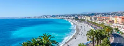 a view of a beach with palm trees and the ocean at Cozy appartment downtown Nizza 2 Bedroom 1 min Beach 1 min tramway 10min airport air conditionner in Nice