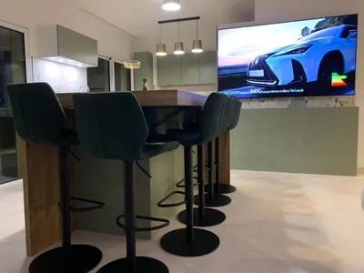 a kitchen with a bar with four green bar stools at Appartement d'exception vue mer Nice Blue Pearl in Nice