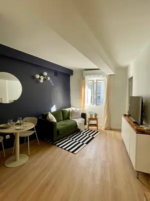 a living room with a green couch and a table at Cosy 1 Bedroom Place Massena in Nice