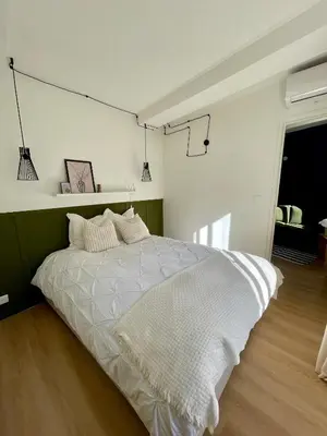 a bedroom with a white bed and a green wall at Cosy 1 Bedroom Place Massena in Nice